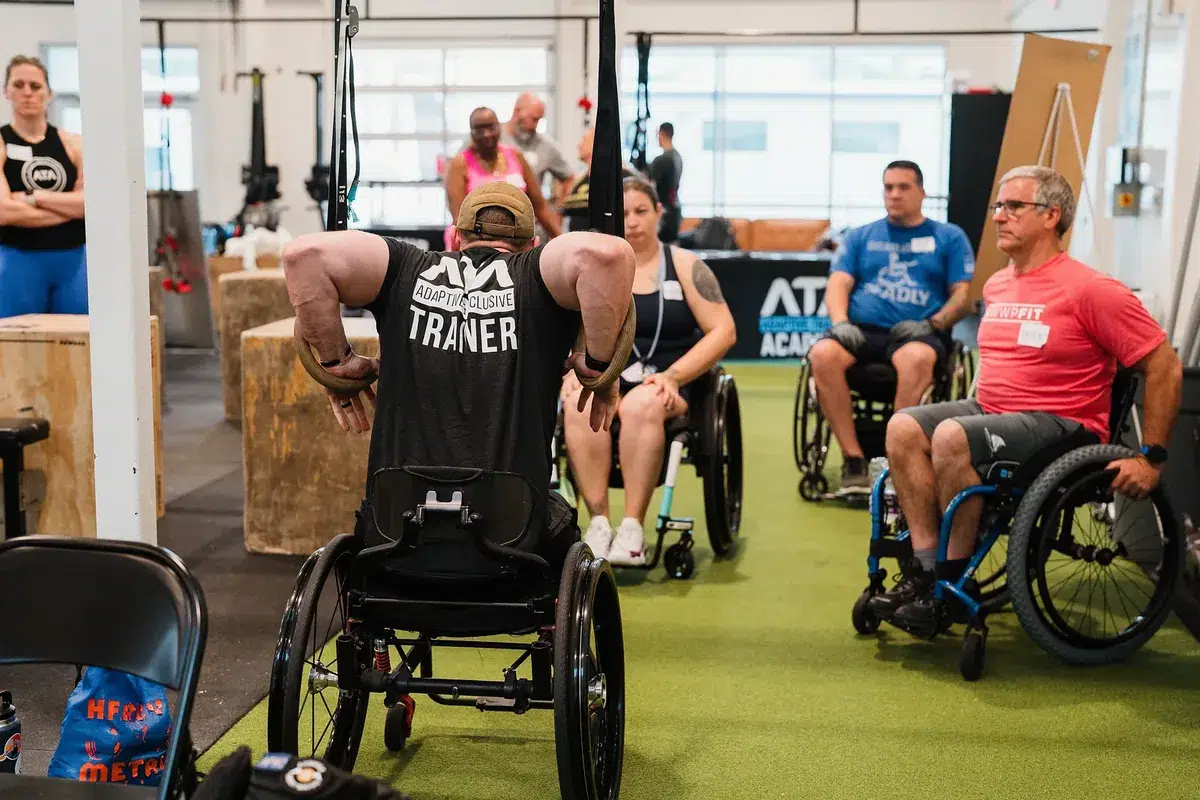 An ATA trainer demonstrates a movement from his wheelchair to seated seminar attendees